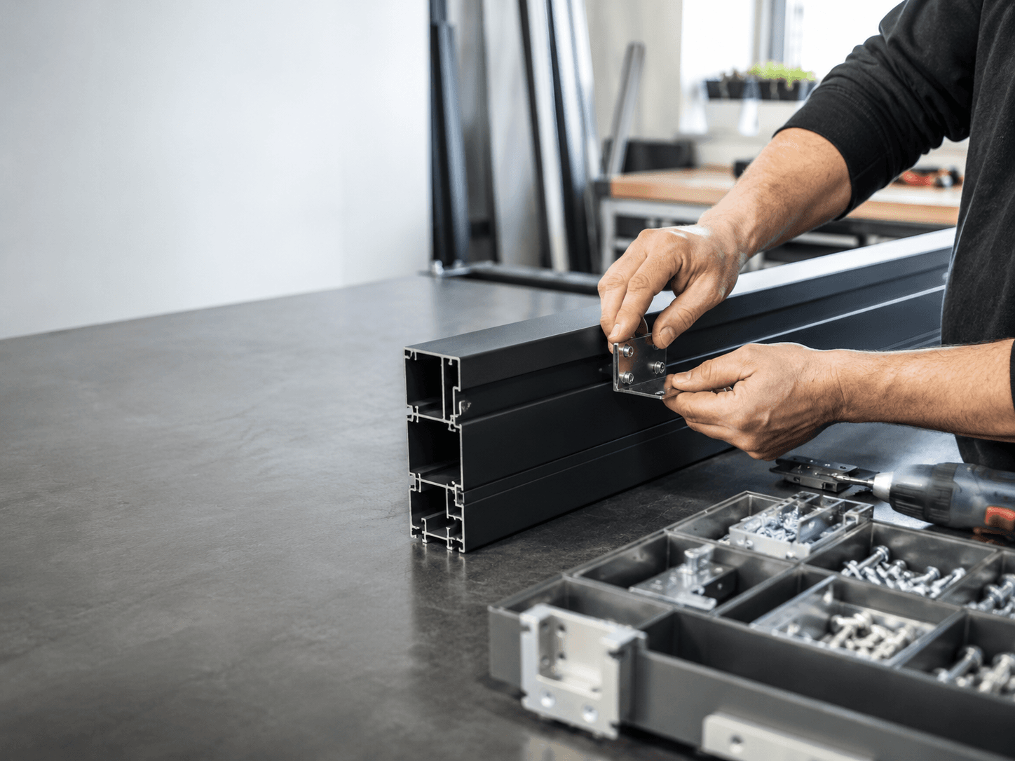 Produktion: anthrazitfarbene Aluminiumprofile werden in der Werkstatt montiert